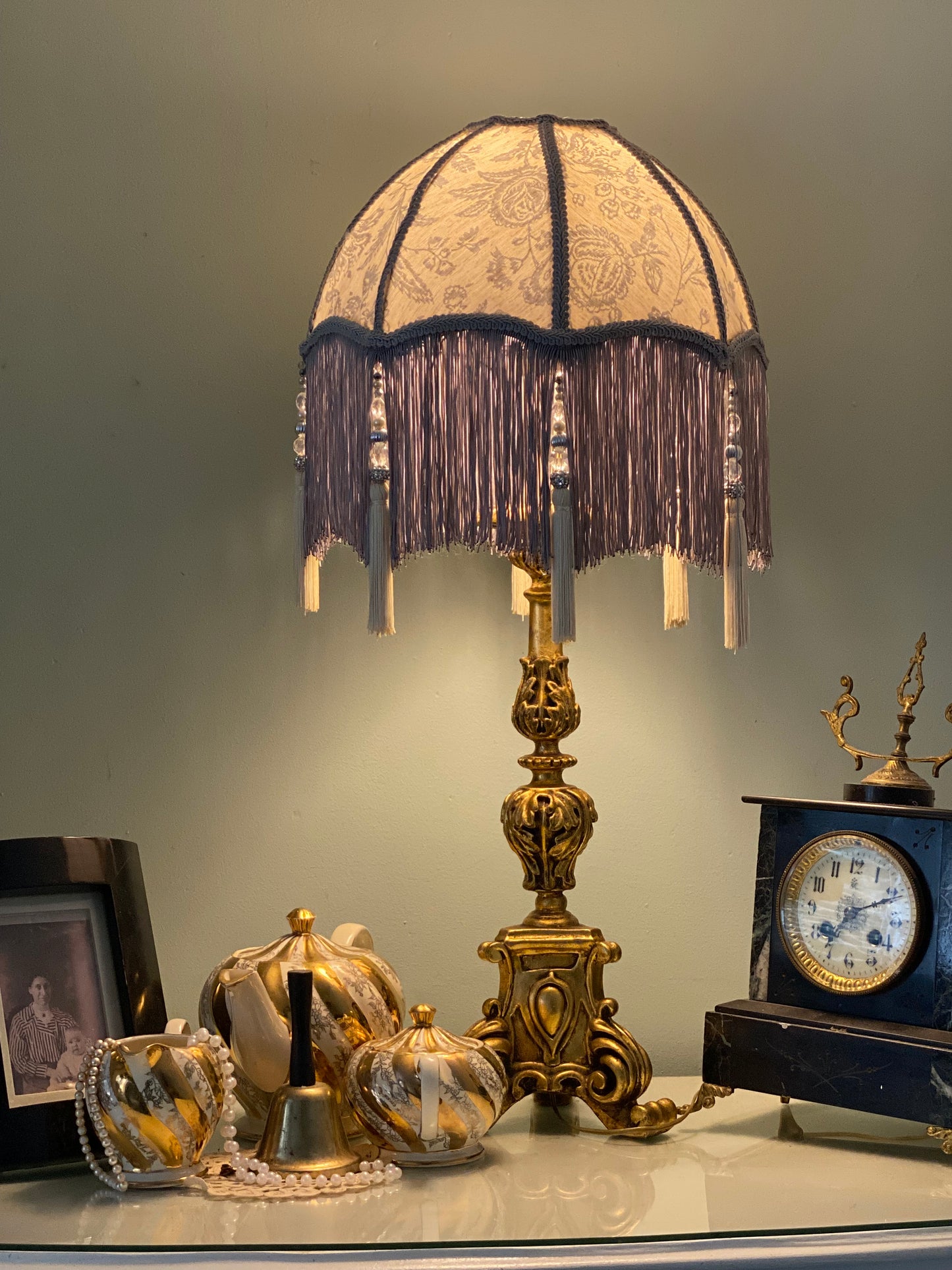 . Full lampshade view – A grey Victorian parachute-style lampshade in blue toile fabric, with a soft scalloped shape and a long beaded fringe.