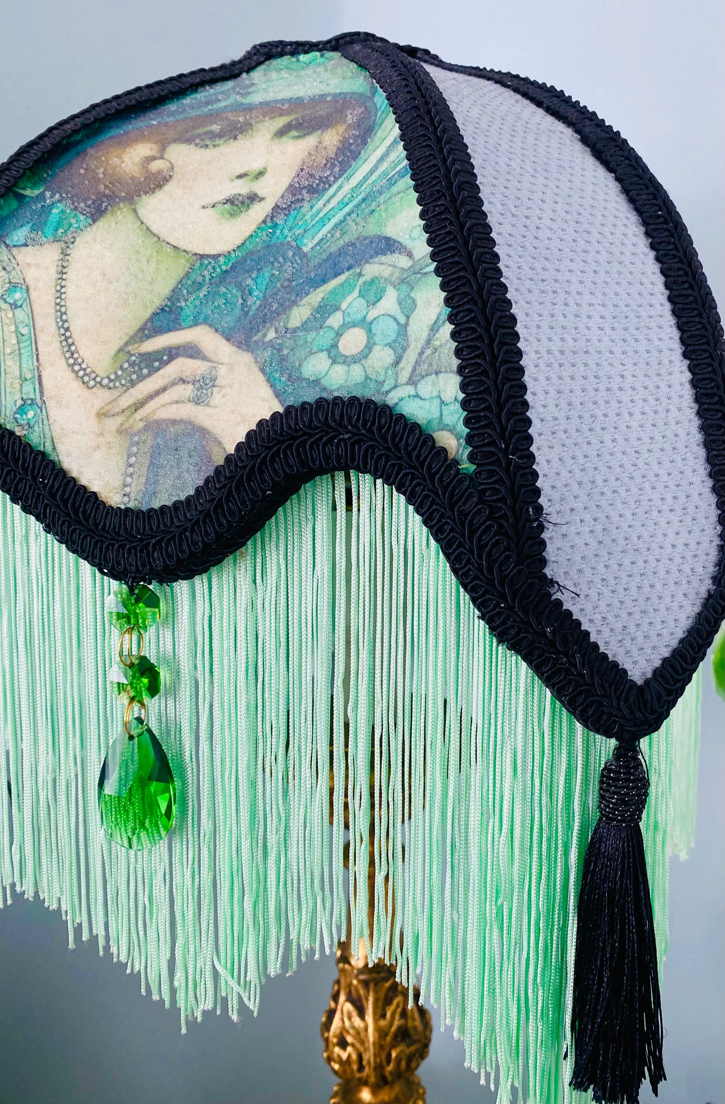 Side angle / lifestyle setting – “Victorian-style parlour lampshade with Edwardian lady portrait and emerald accents, black lace panels, and glow-in-the-dark green fringe – vintage statement lighting.”