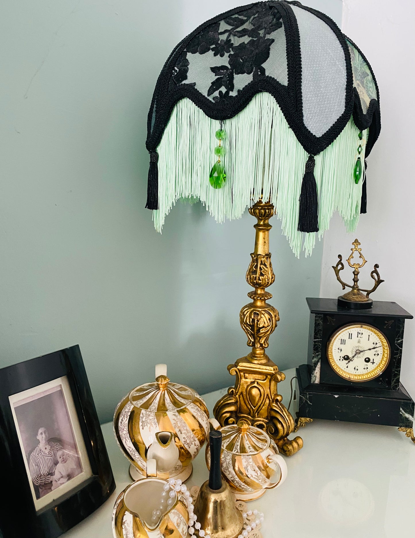 Side angle / lifestyle setting – “Victorian-style parlour lampshade with Edwardian lady portrait and emerald accents, black lace panels, and glow-in-the-dark green fringe – vintage statement lighting.”2