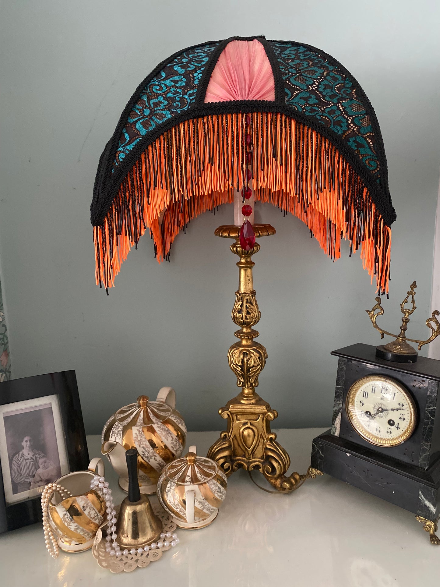Handmade Art Deco crescent-shaped lampshade with red pleated fan panels, green and black lace over orange silk, and fluorescent orange fringe – vintage
