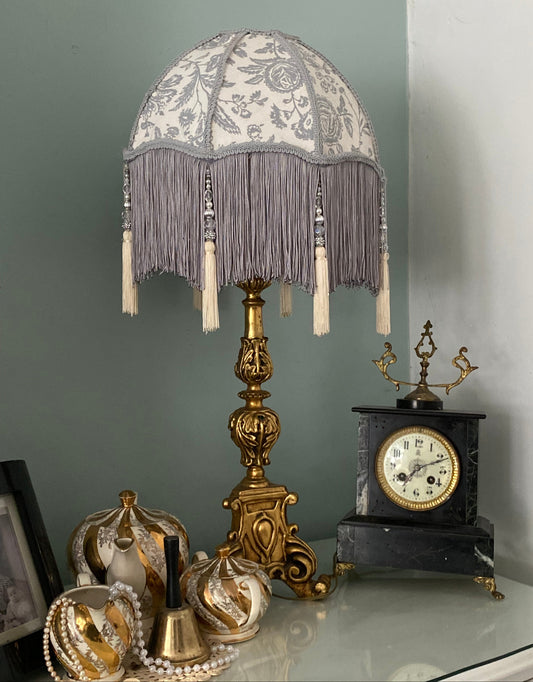 Full lampshade view – A grey Victorian parachute-style lampshade in blue toile fabric, with a soft scalloped shape and a long beaded fringe.