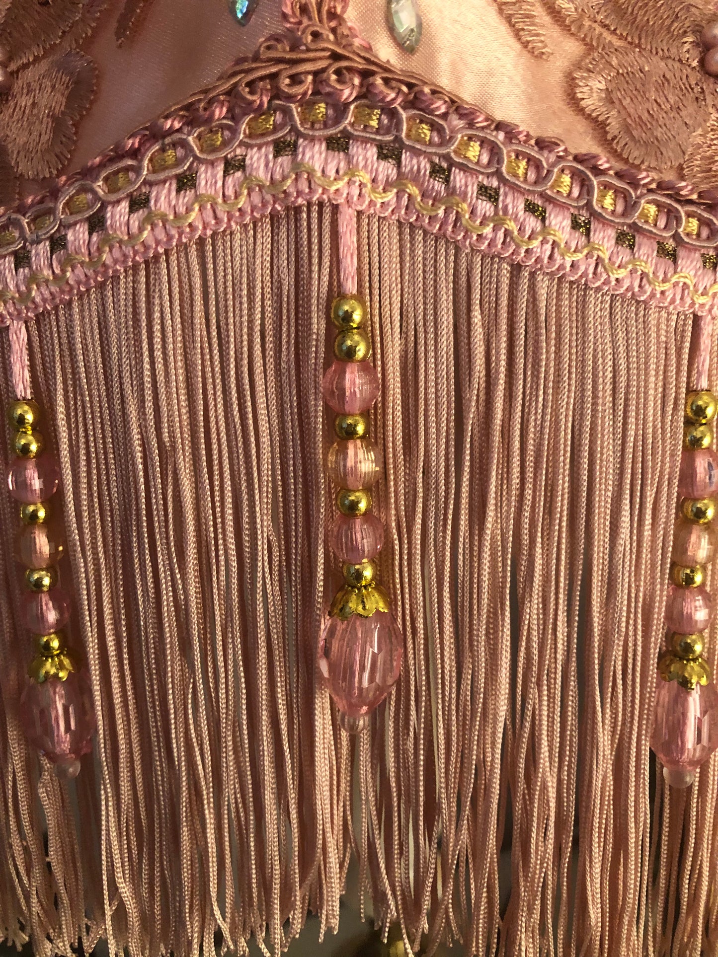 Close-up of fringe detail – “Soft pink fringe and matching pink beaded trim along the edge of a Victorian silk lampshade – antique-inspired handmade finish.”