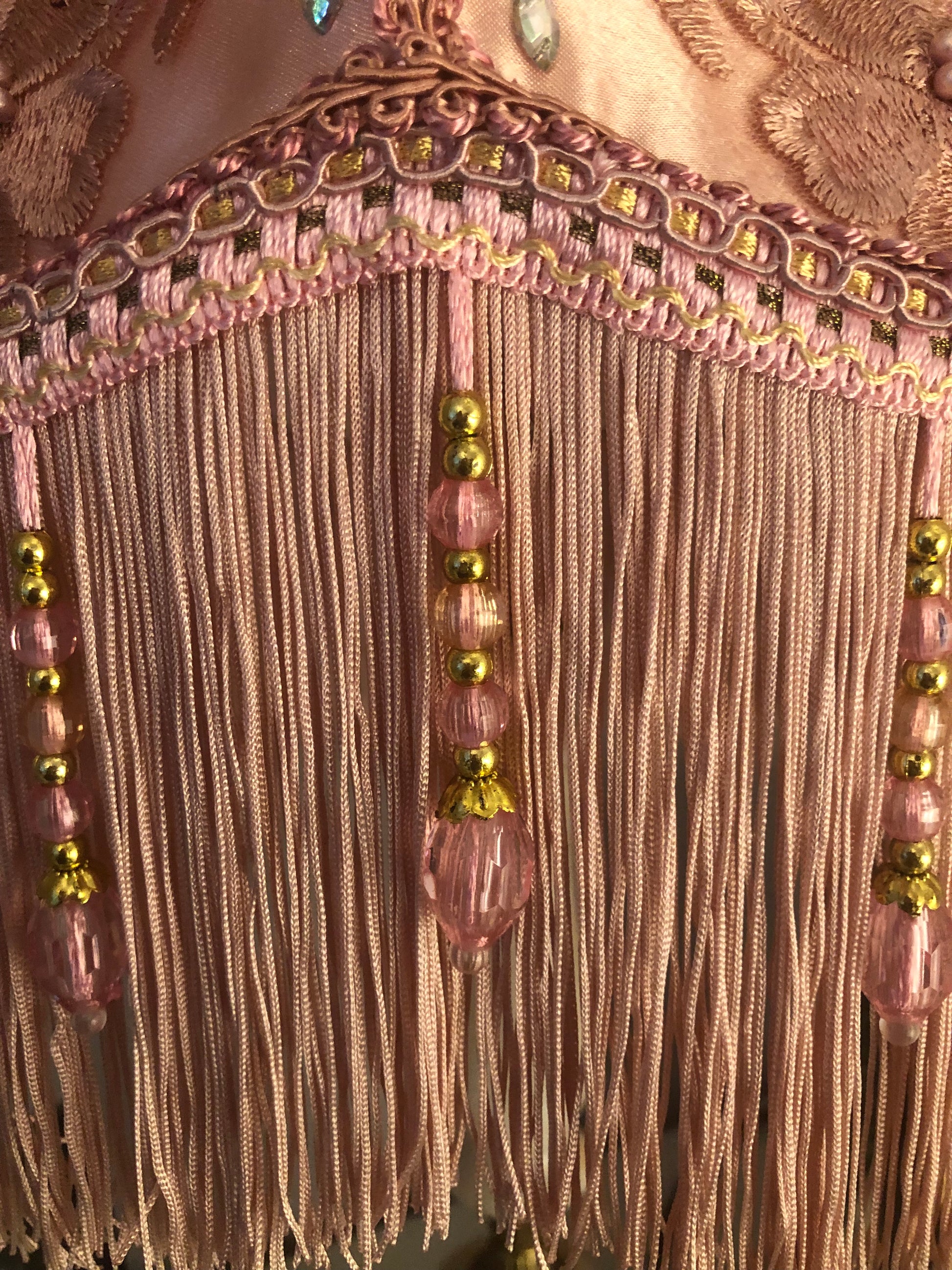 Close-up of fringe detail – “Soft pink fringe and matching pink beaded trim along the edge of a Victorian silk lampshade – antique-inspired handmade finish.”