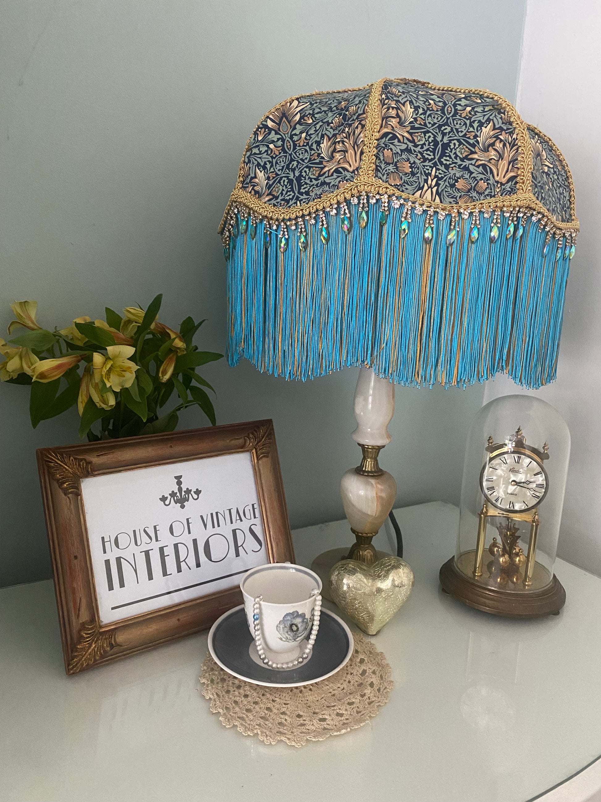 Angled shot, unlit
Handmade Art Deco lampshade in William Morris “Snakeshead” turquoise fabric, shown unlit at an angle to highlight the gold and turquoise two-tone fringe, gold braid trim, and iridescent diamanté detail — elegant Victorian-inspired fringed lighting. two