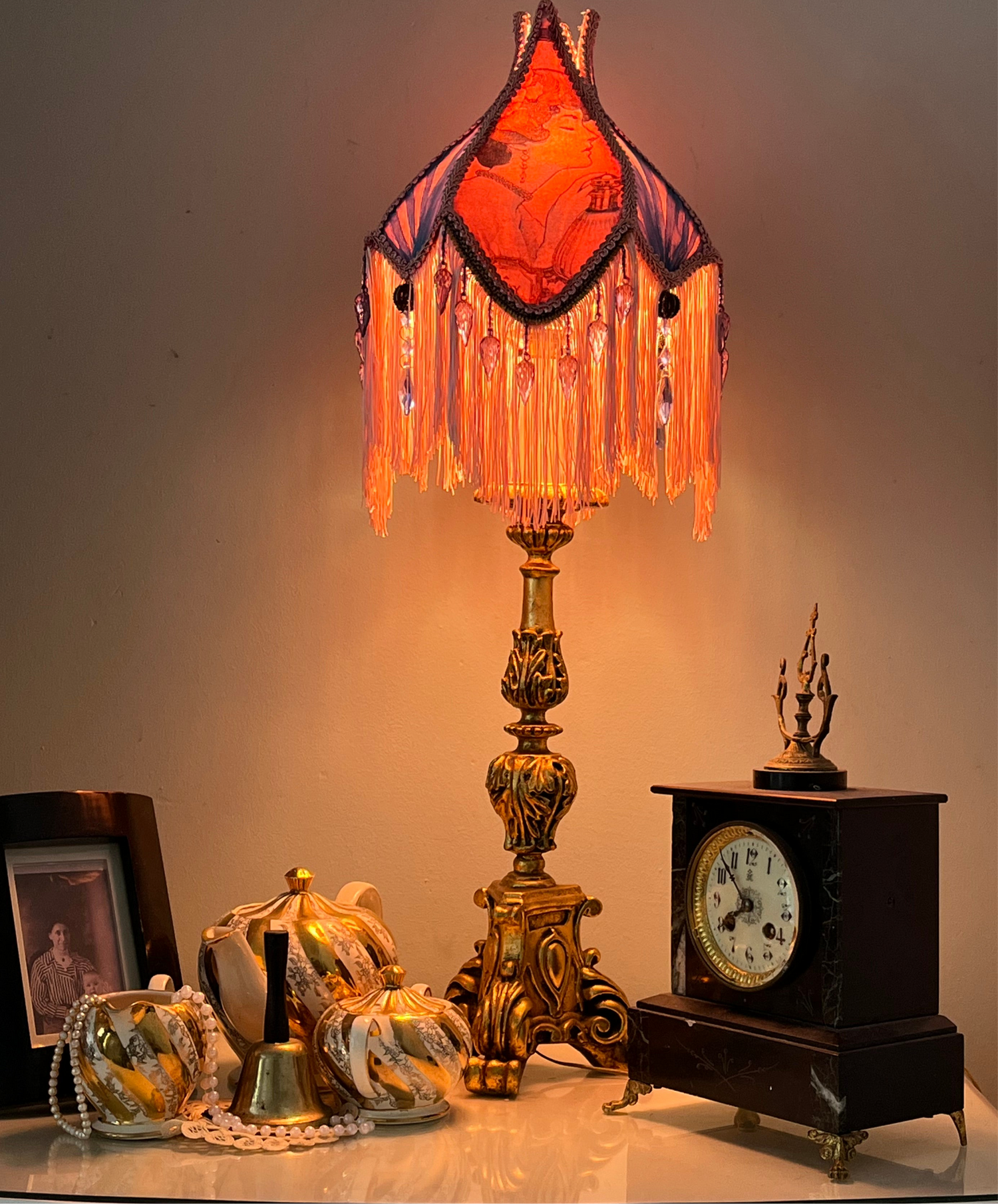 Lit ambience shot – “Victorian tulip-shaped silk lampshade illuminated to reveal Edwardian lady image, lace details, and pastel glow – romantic vintage lighting for elegant interiors.” with clock