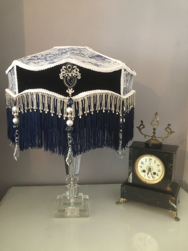victorian_fringed_lampshade, in blue velvet toile and lace, with diamantes and blue fringe next to an antique clock