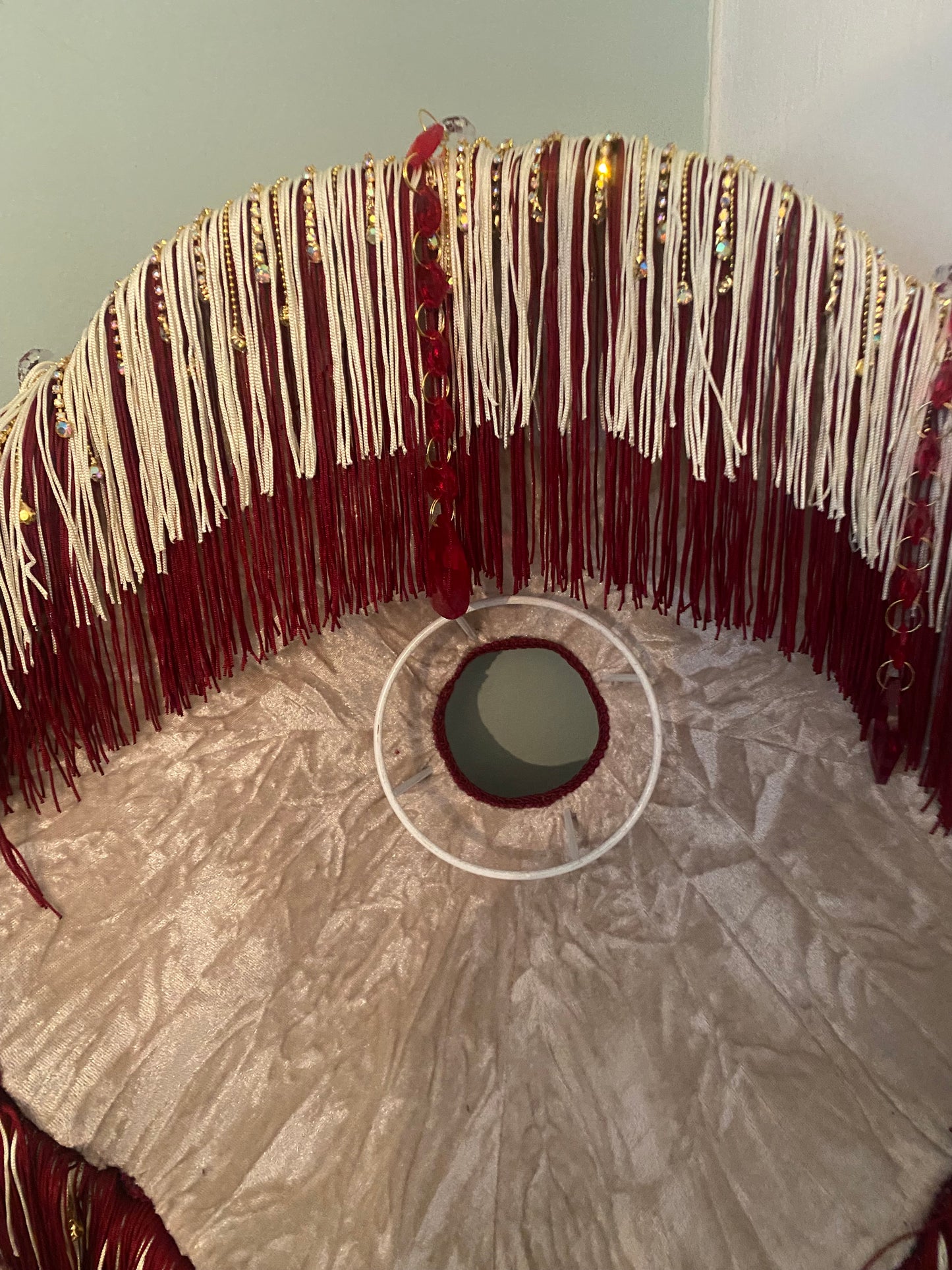 Fabric and texture detail – “William Morris ‘Brer Rabbit’ fabric with rich woven detail, paired with burgundy trim and gold diamante fringe on a Victorian-style lampshade.”interior lining detail